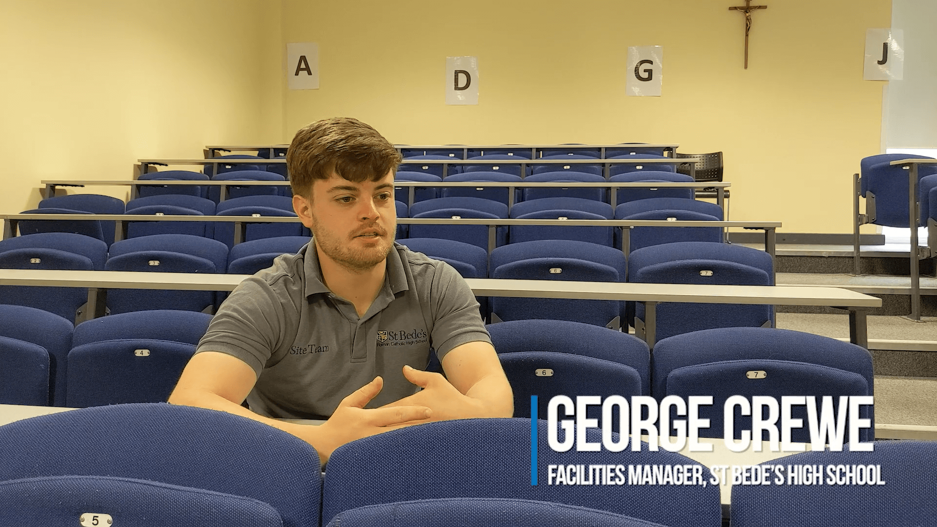 George Crewe, Facilities Manager at St Bedes Catholic School, speaking about the Audiebant system installation, seated in the lecture hall.